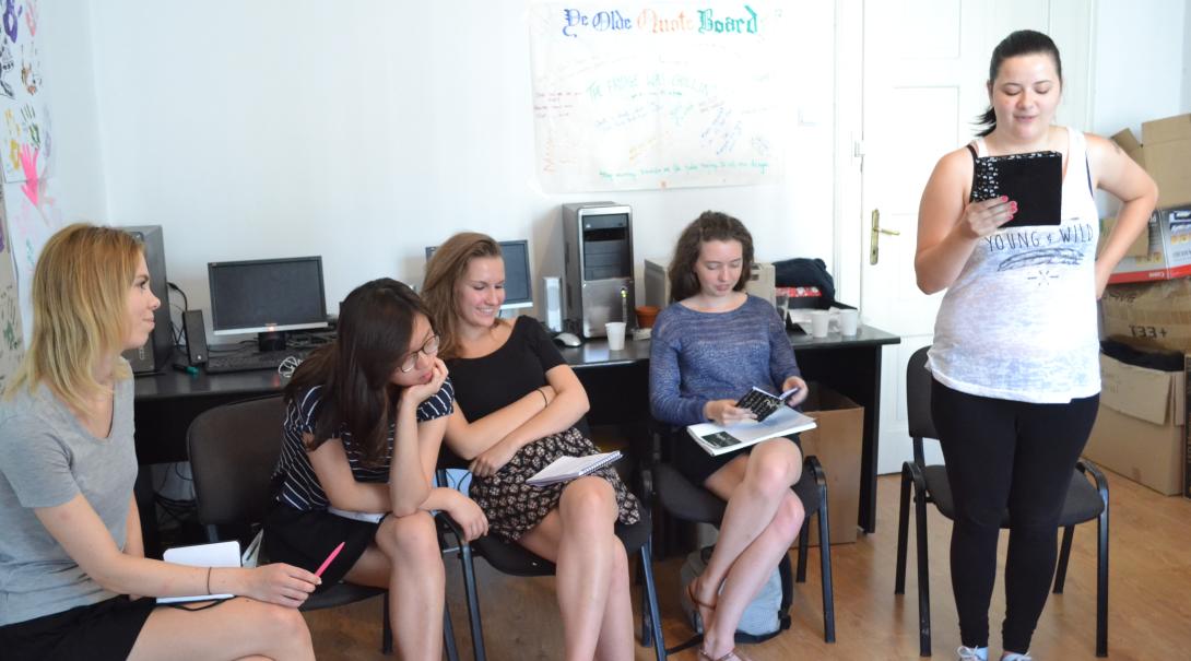 Teenage volunteers work as a group to find the best stories for the magazine Journalism volunteers discuss their story ideas as part of their Journalism Project for teenagers